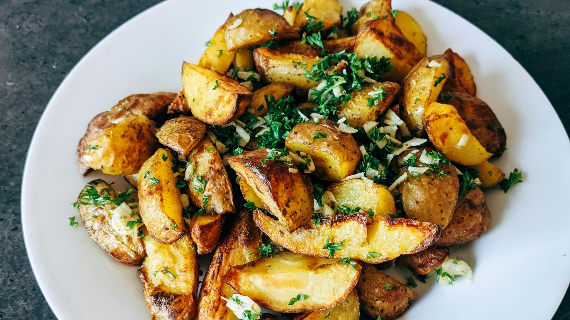 a white plate topped with potatoes and parsley