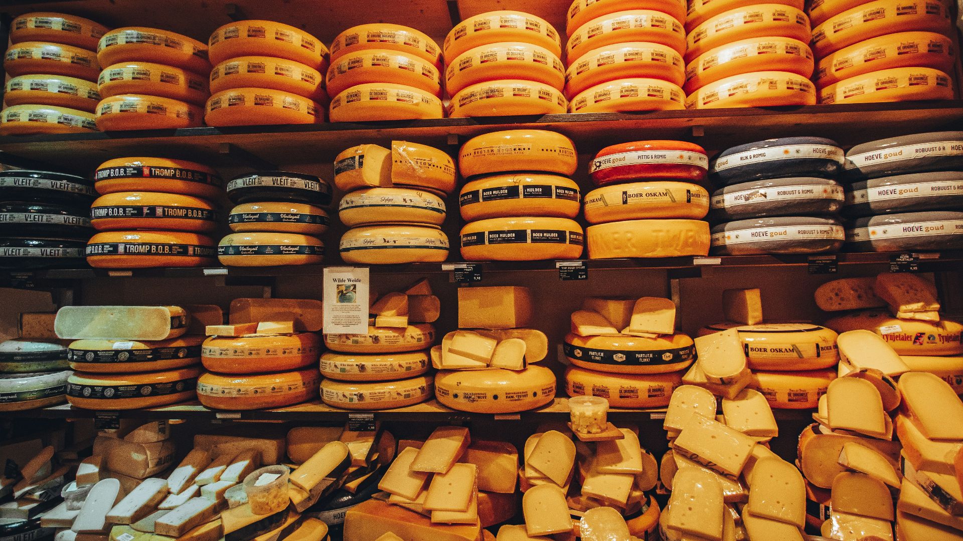 a shelf filled with lots of cheese covered in cheese