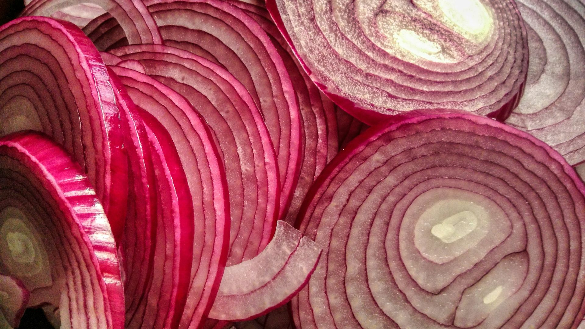 A pile of red onions sitting on top of a table