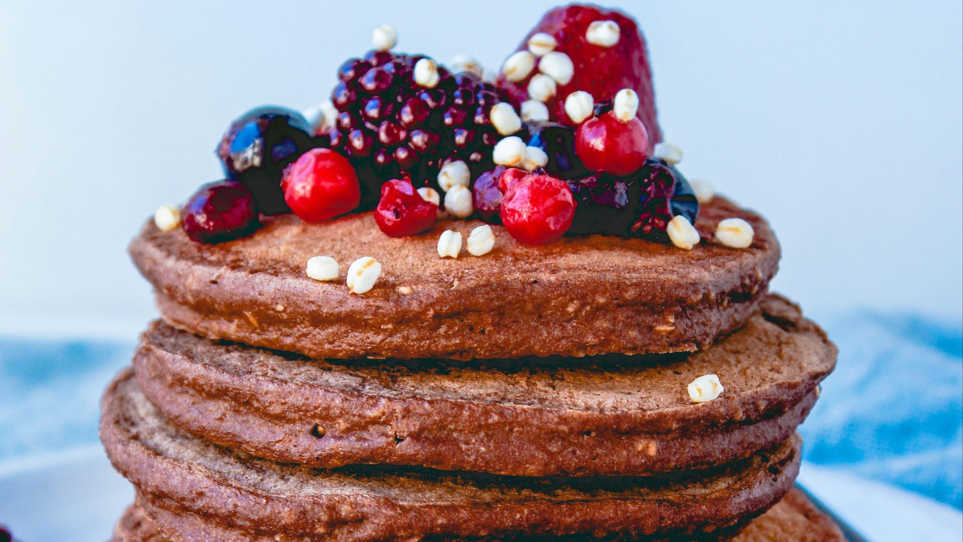 a stack of chocolate pancakes with berries on top