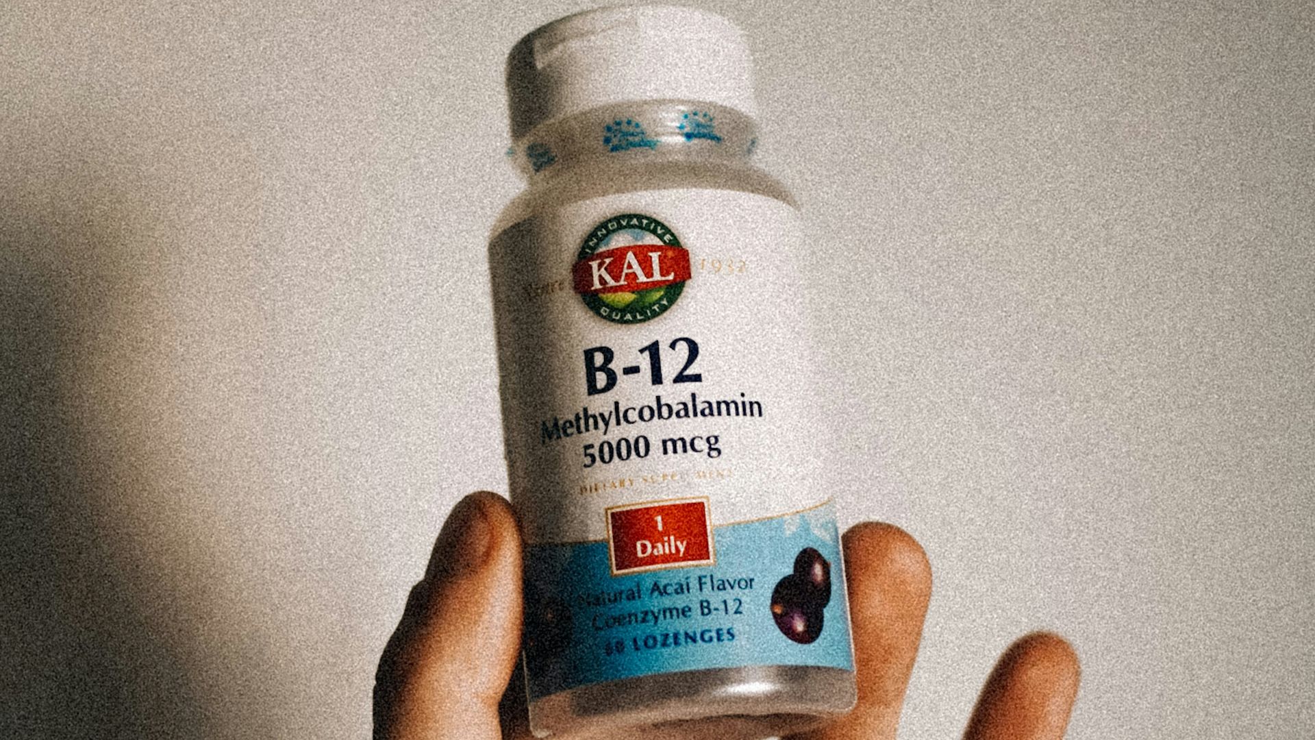 a person holding a bottle of vitamins in their hand