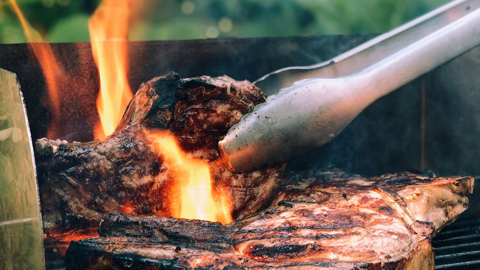 gray metal tong and grilled meat with fire