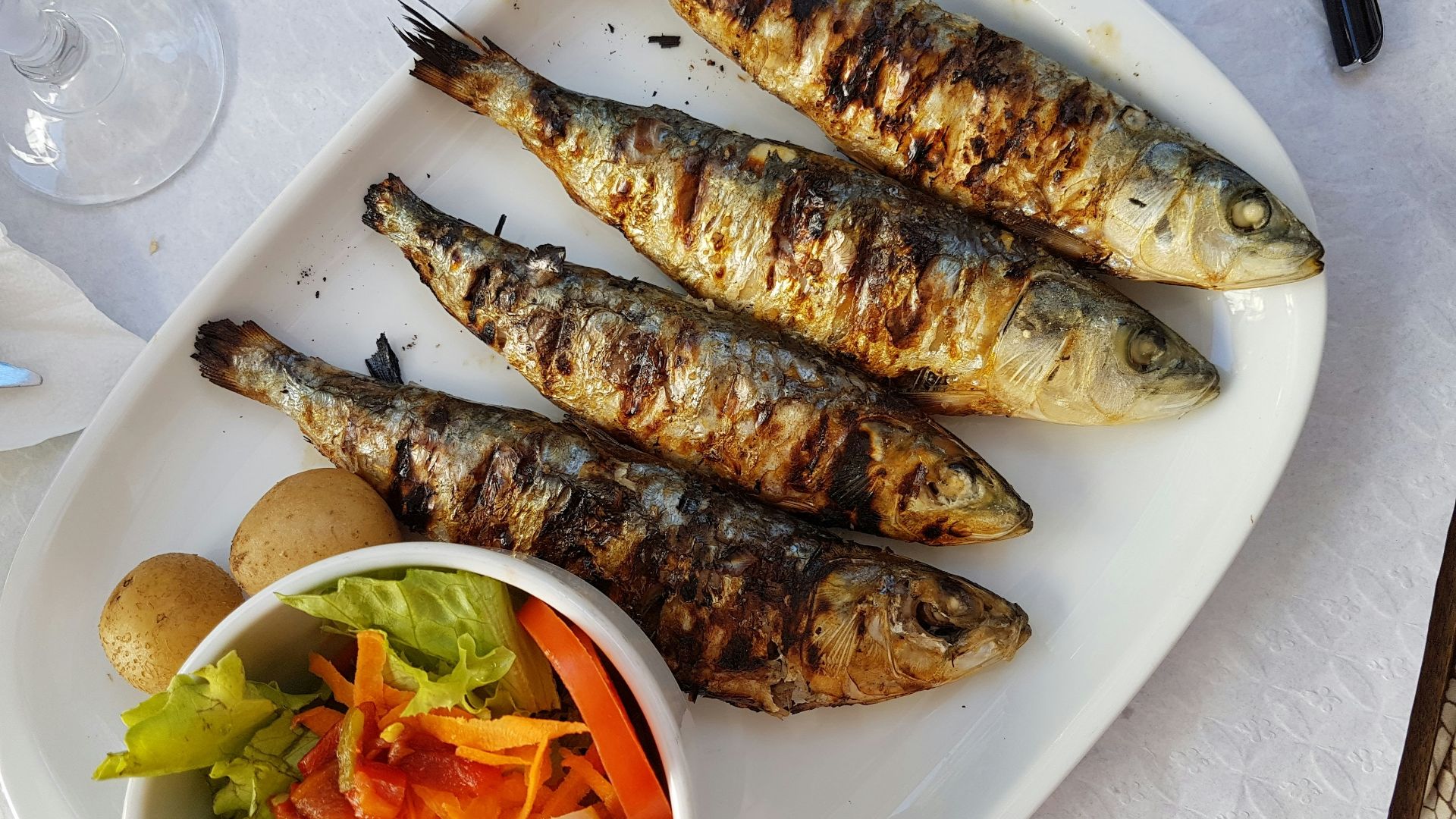 grilled fish with vegetable salad on white ceramic plate