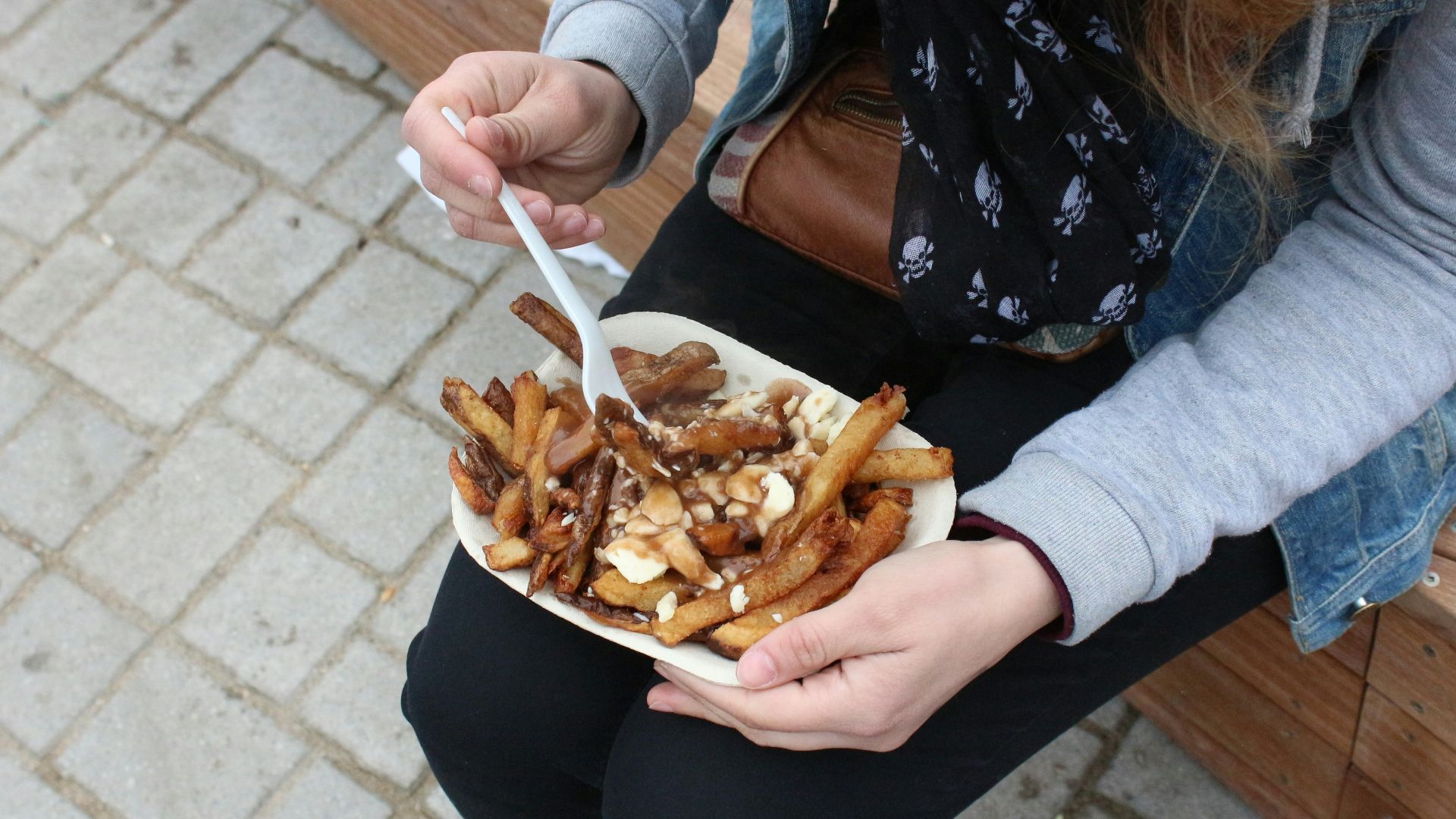 person holding burger with fries