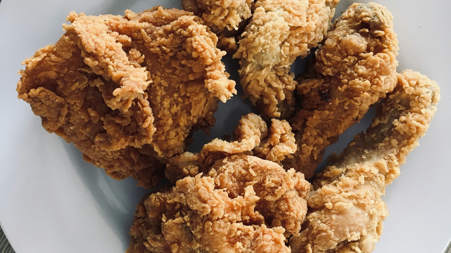 a white plate topped with fried food on top of a wooden table