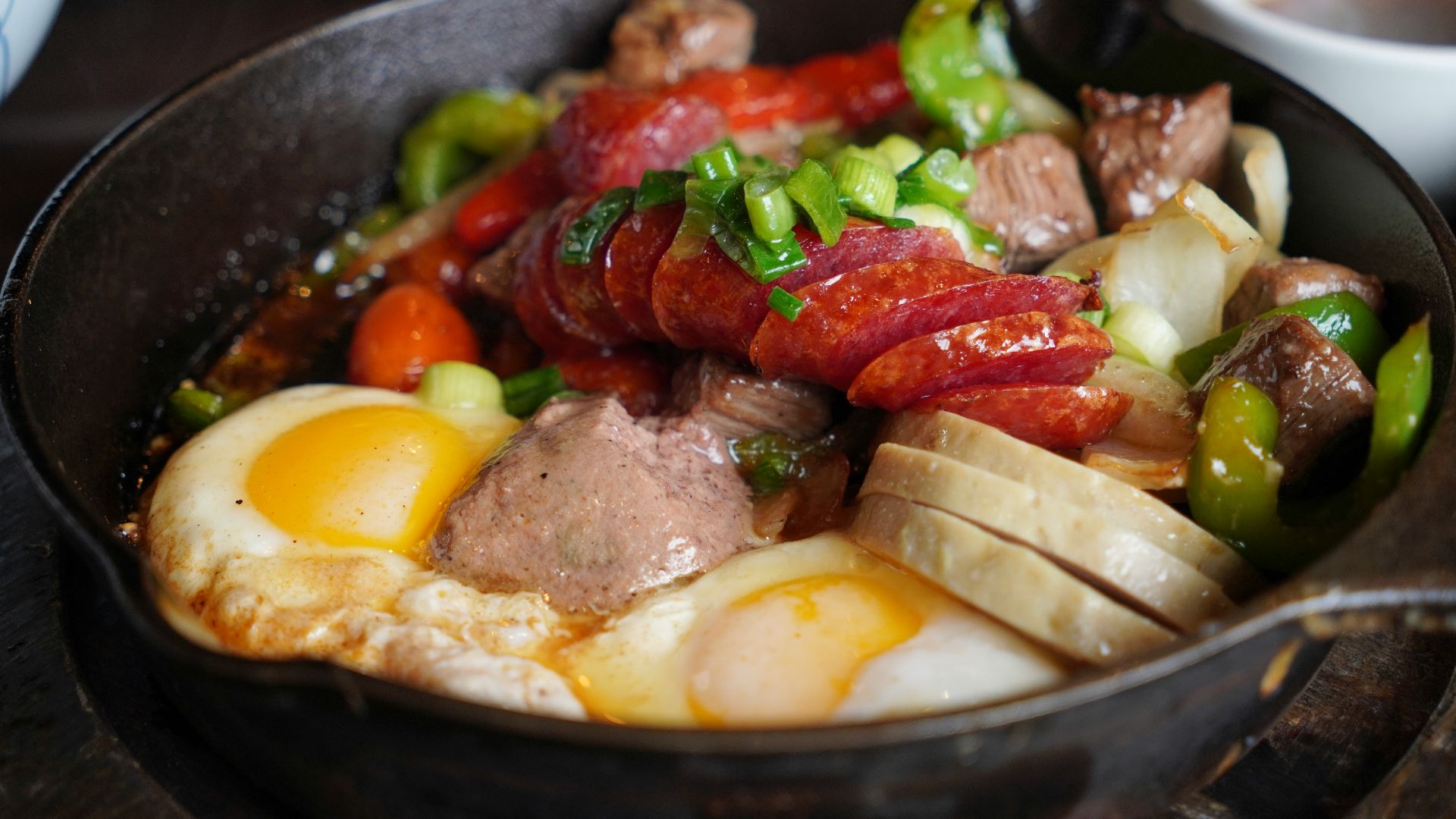 Breakfast skillet with sausage, eggs, and peppers.