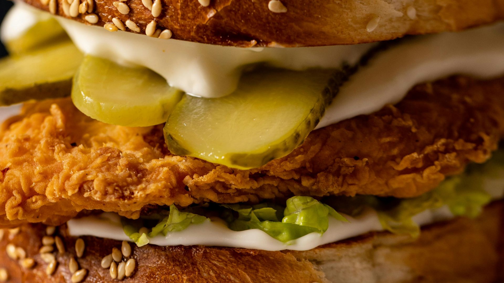 a chicken sandwich with pickles and mayonnaise