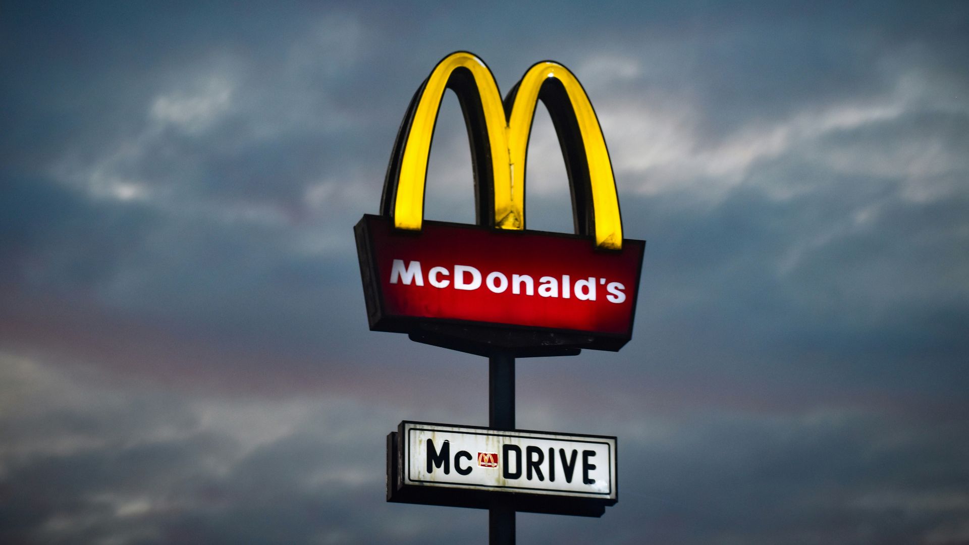 a mcdonald's sign with a cloudy sky in the background