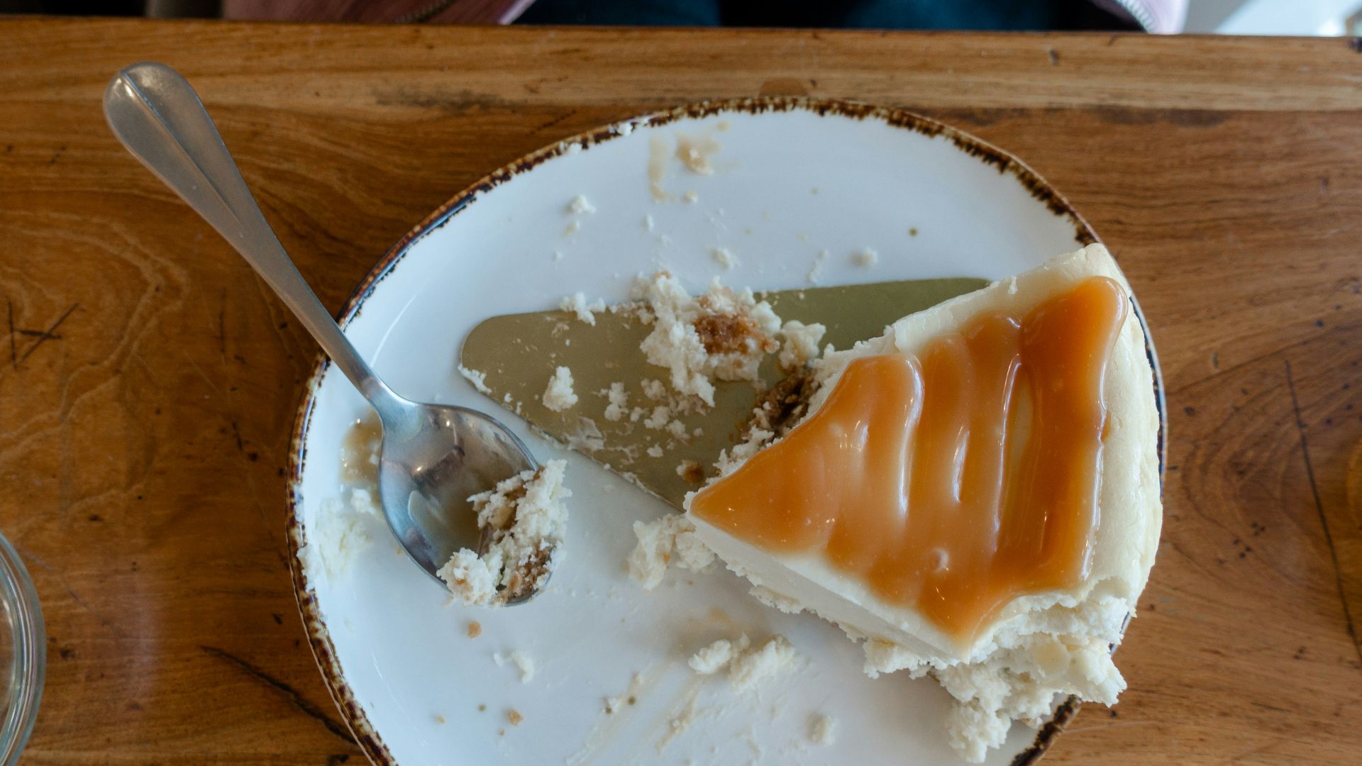 a white plate topped with a piece of cake next to a spoon