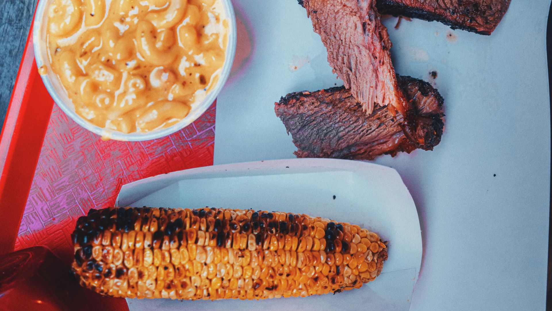 a tray of food that includes corn, macaroni and cheese