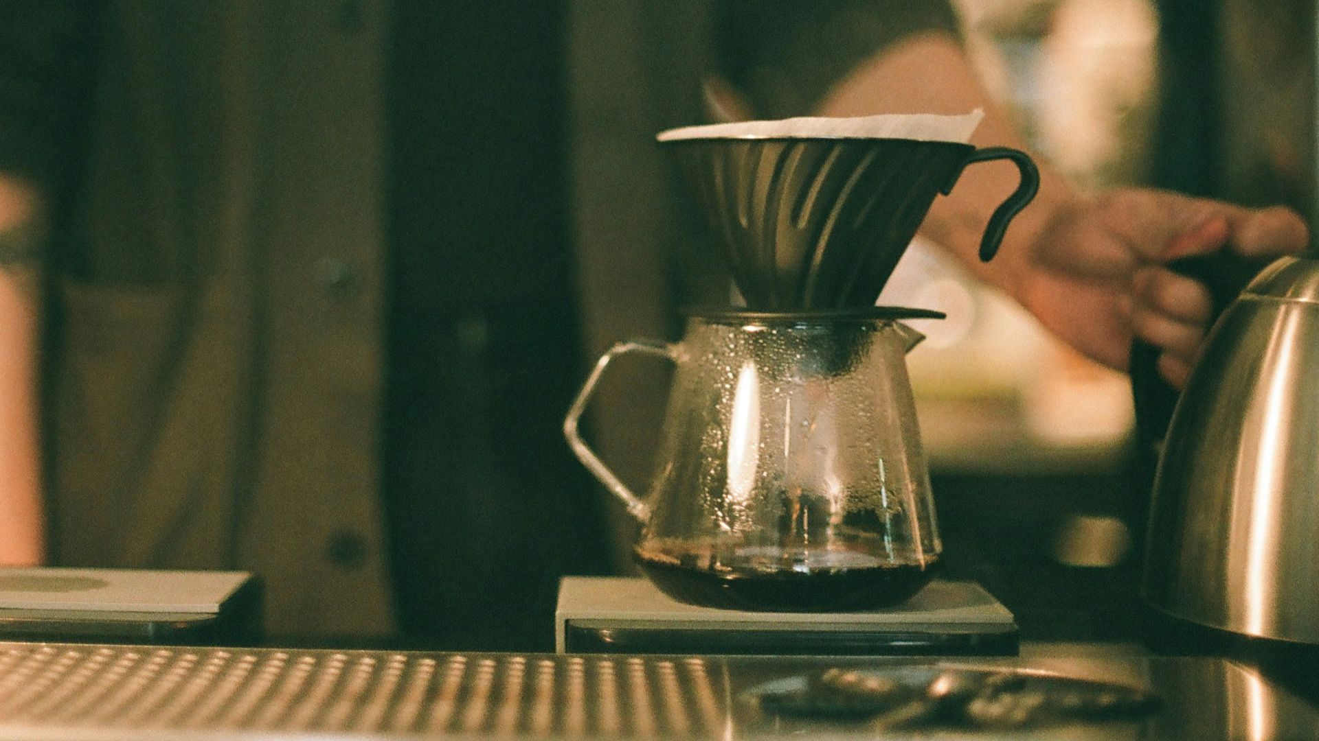 stainless steel teapot on brown wooden table