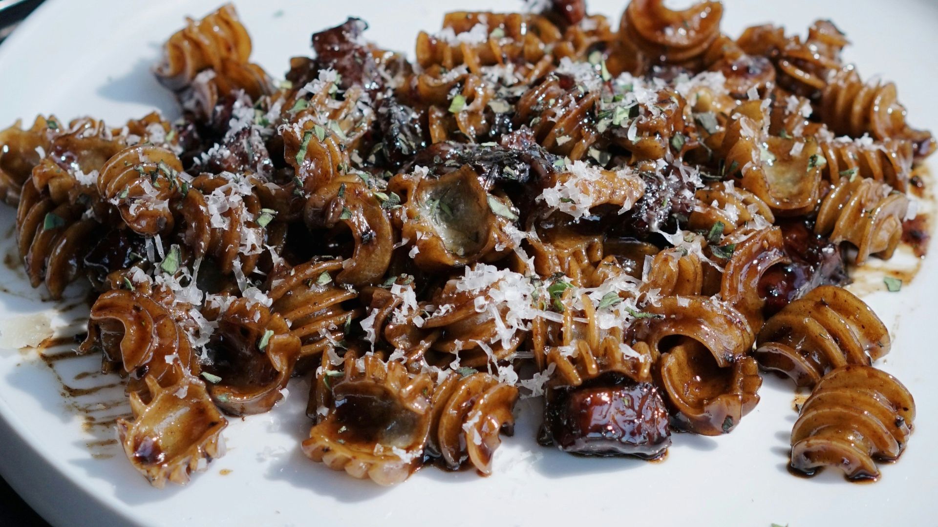 a white plate topped with pasta and meat