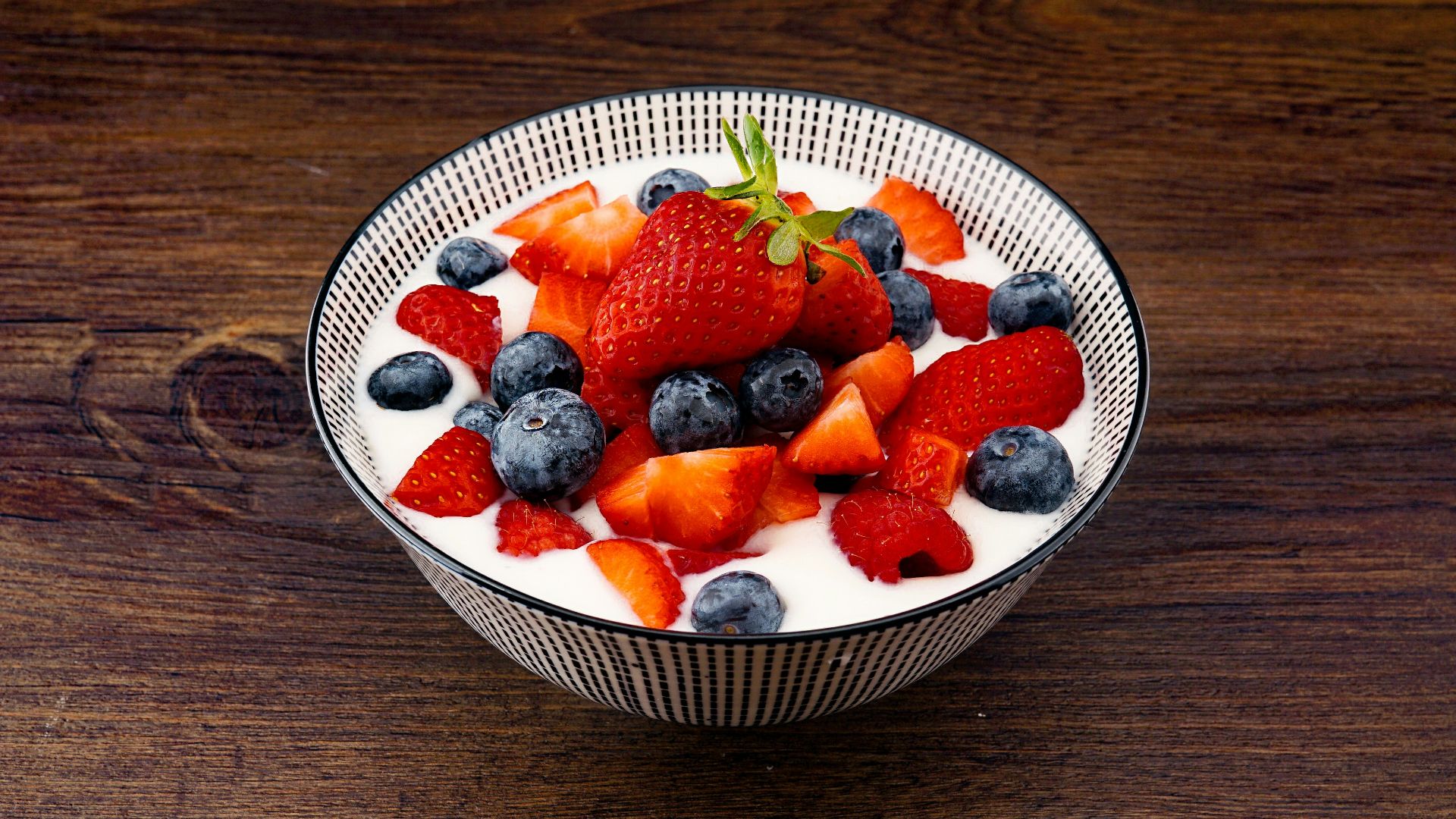 strawberry and blackberries on top of brown table
