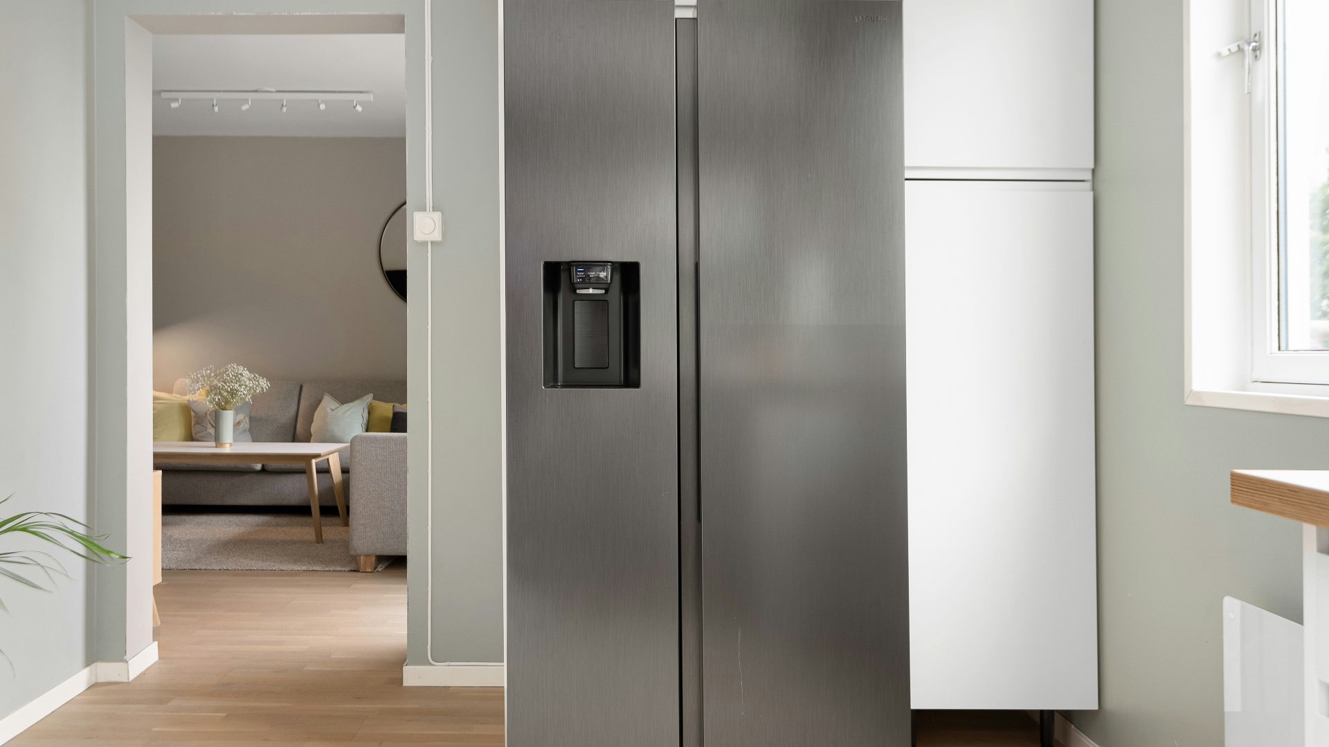 A refrigerator in a kitchen next to a window