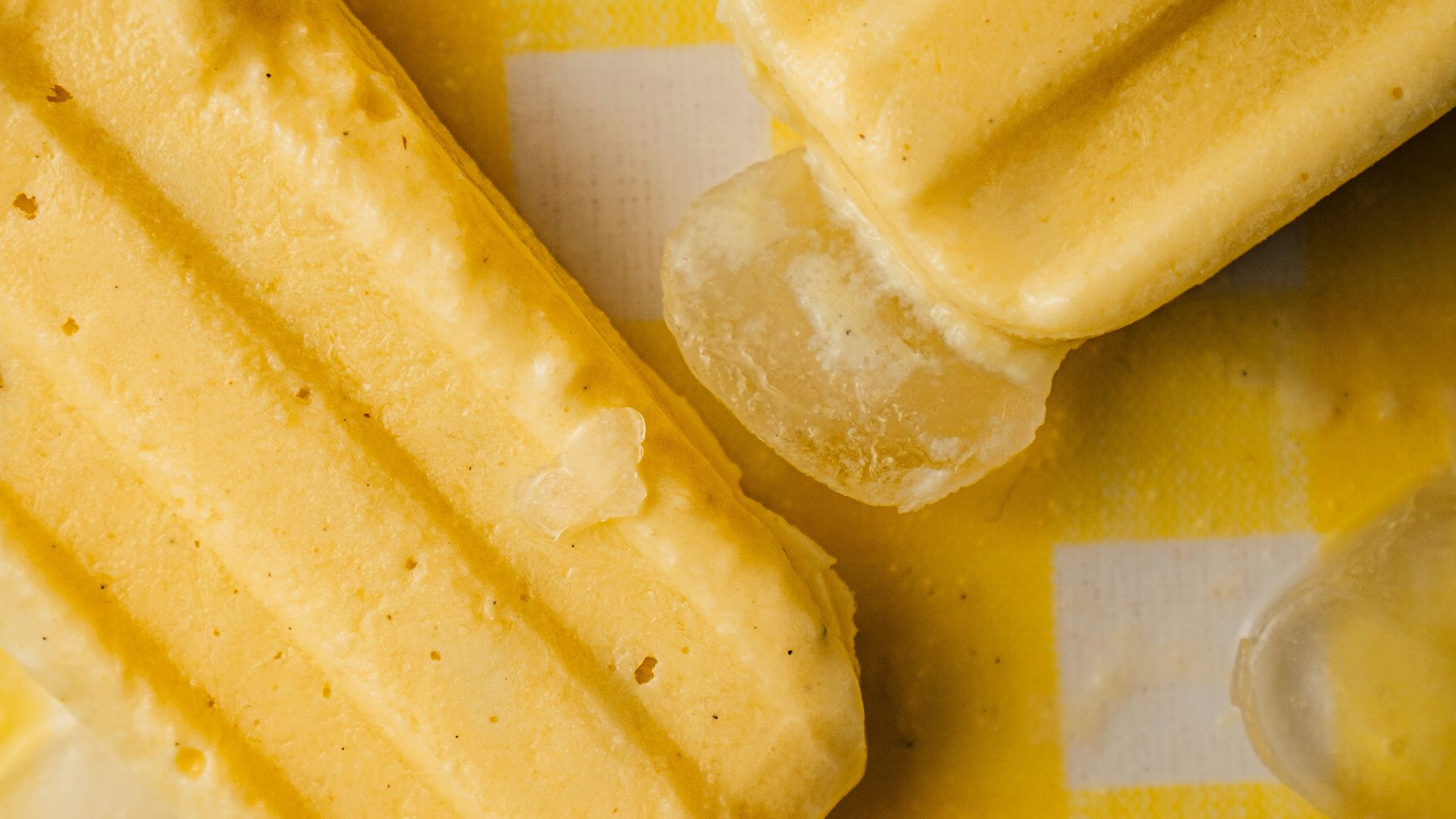 a yellow and white checkered table cloth with ice cream and lemon slices