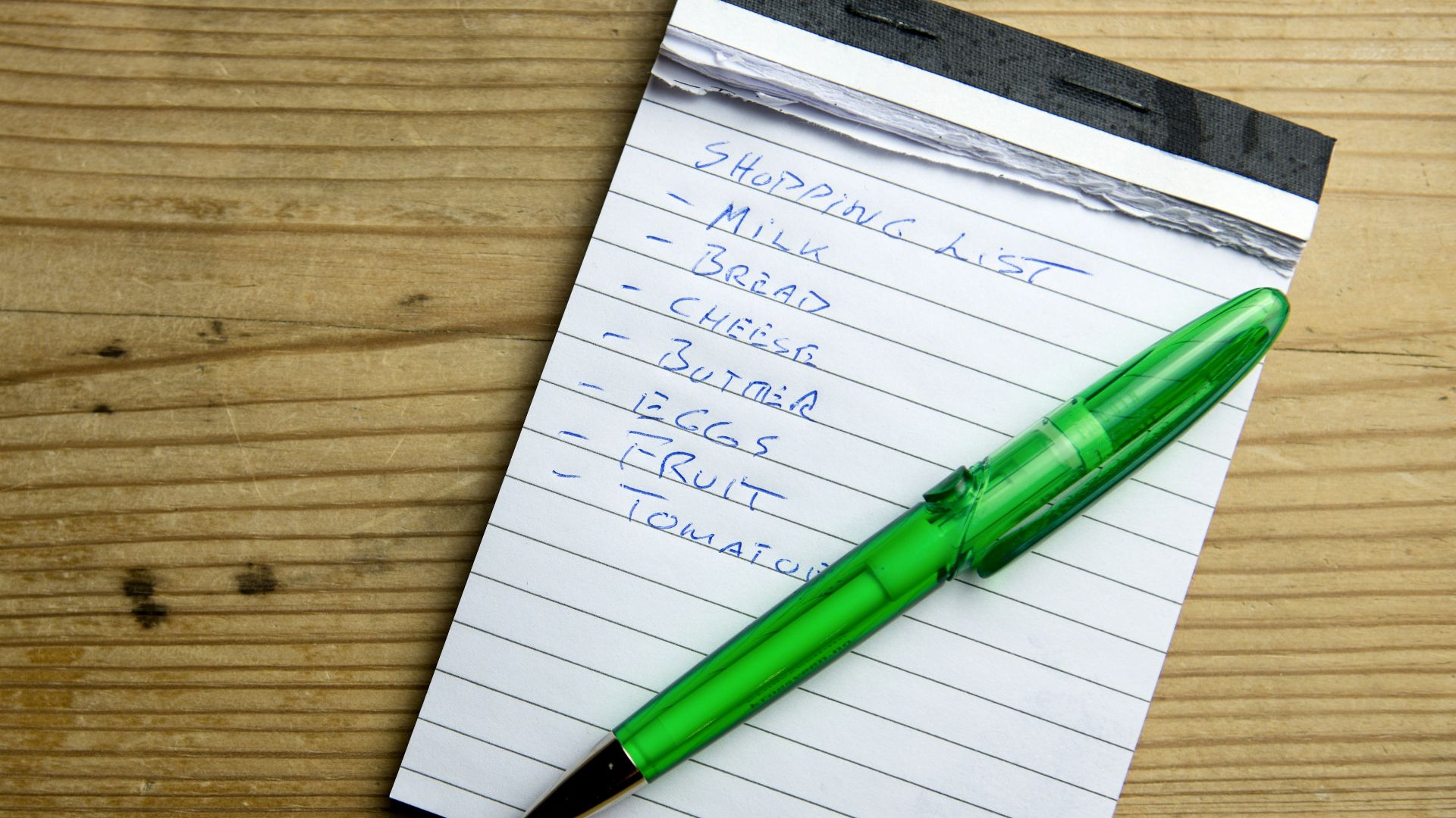 a notepad with a green pen sitting on top of it