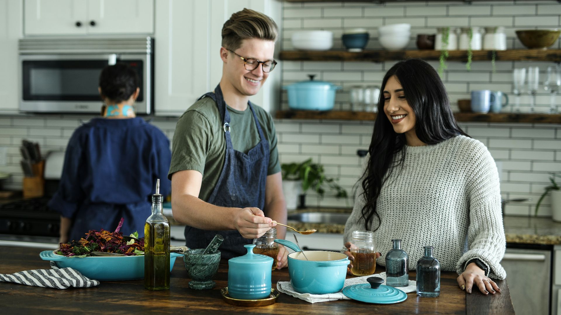 smiling man standing and mixing near woman in kitchen area of the house