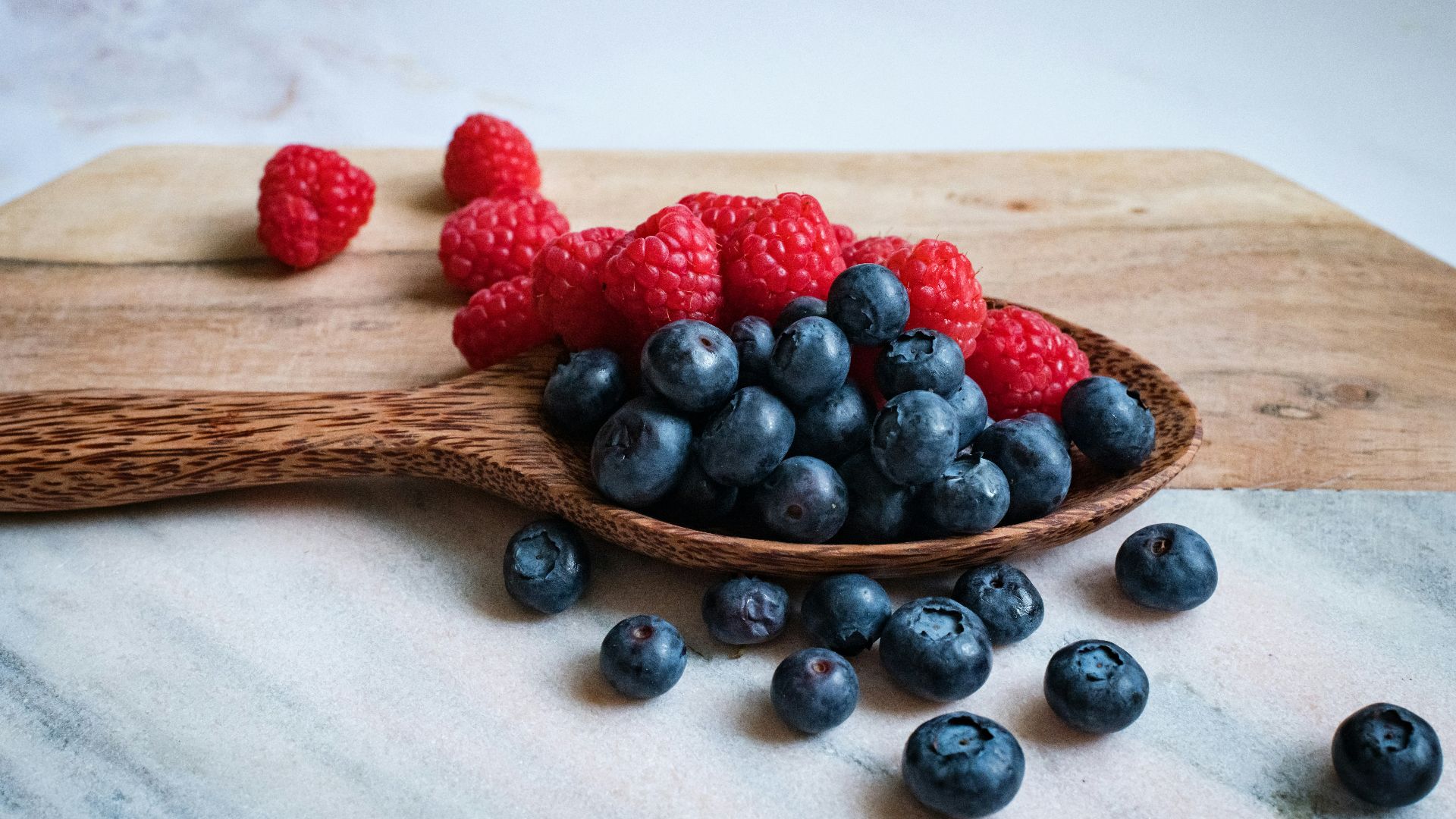 black berries on brown wooden spoon