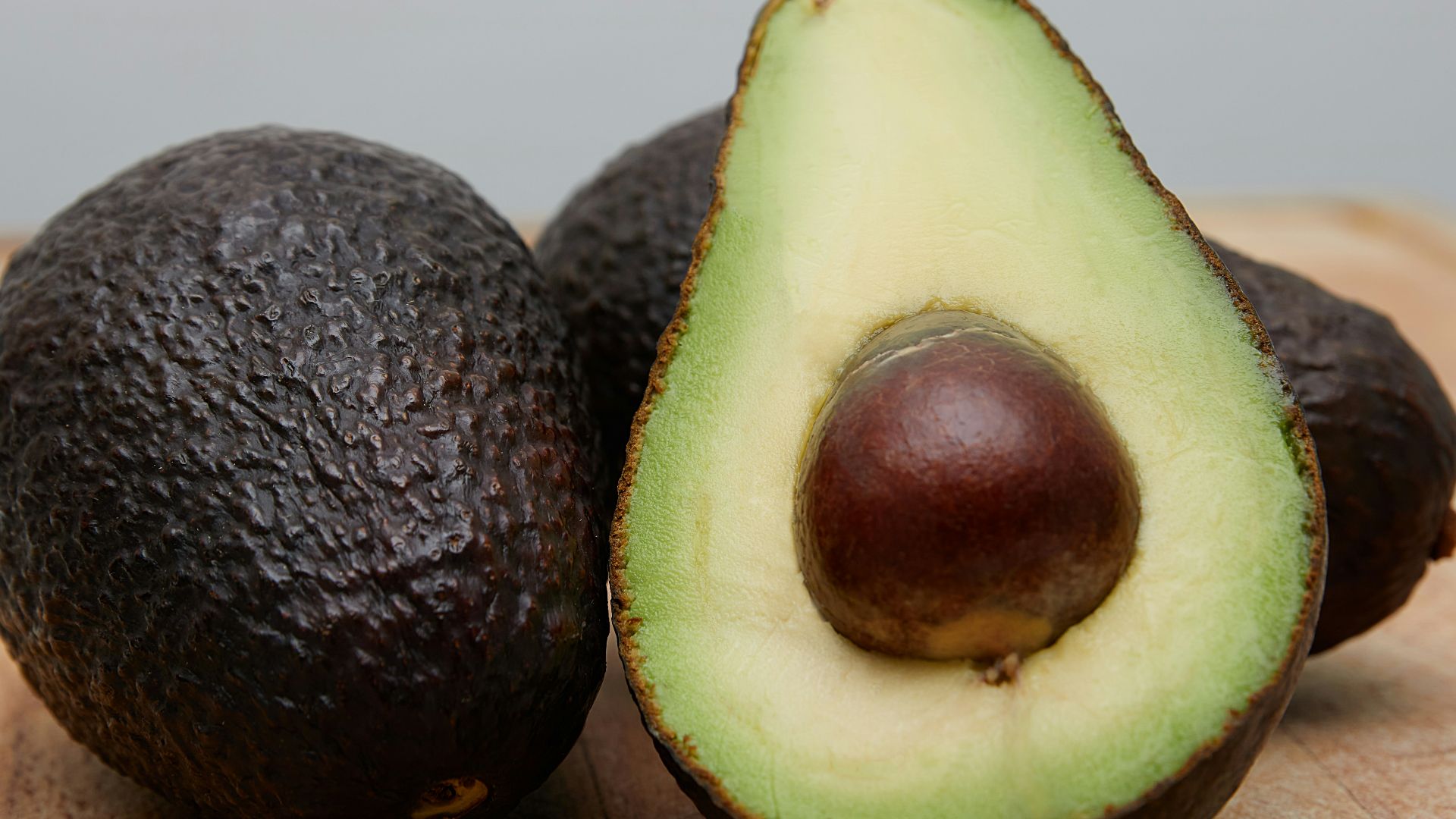 sliced avocado fruit on brown wooden table