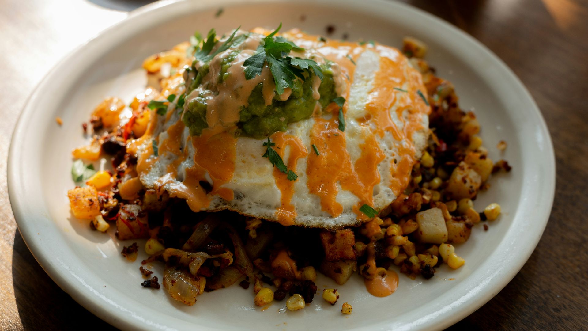 a white plate topped with an egg covered in toppings