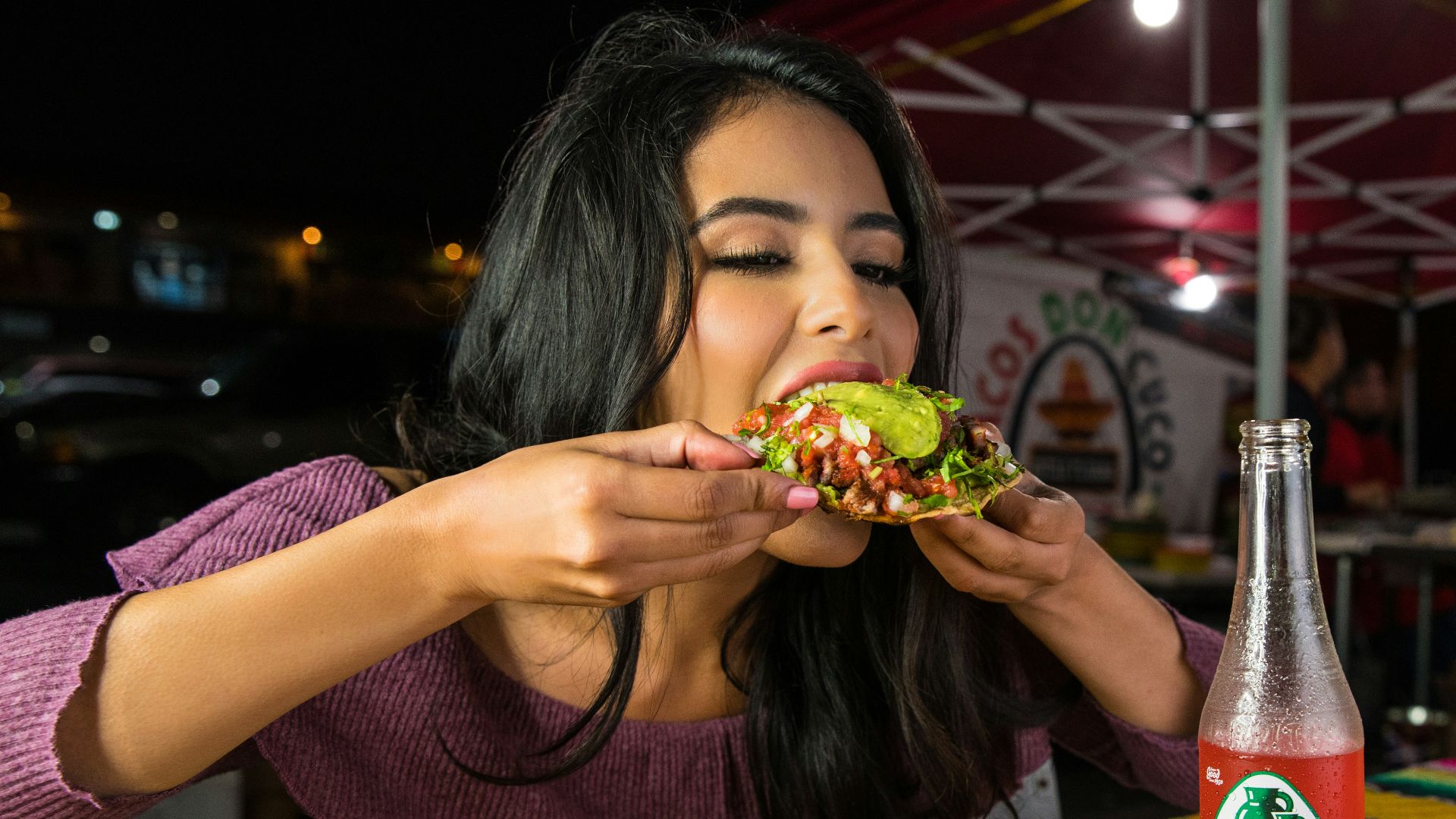 woman in purple shirt holding green and yellow floral ceramic bowl
