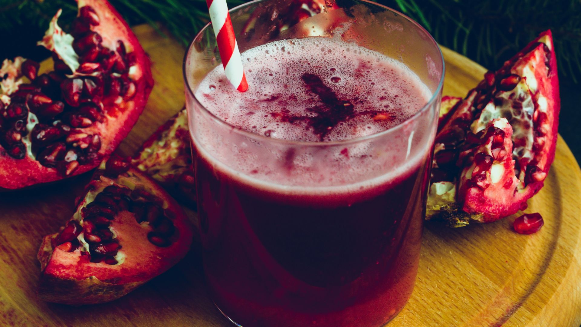 clear drinking glass with red liquid on brown wooden round table