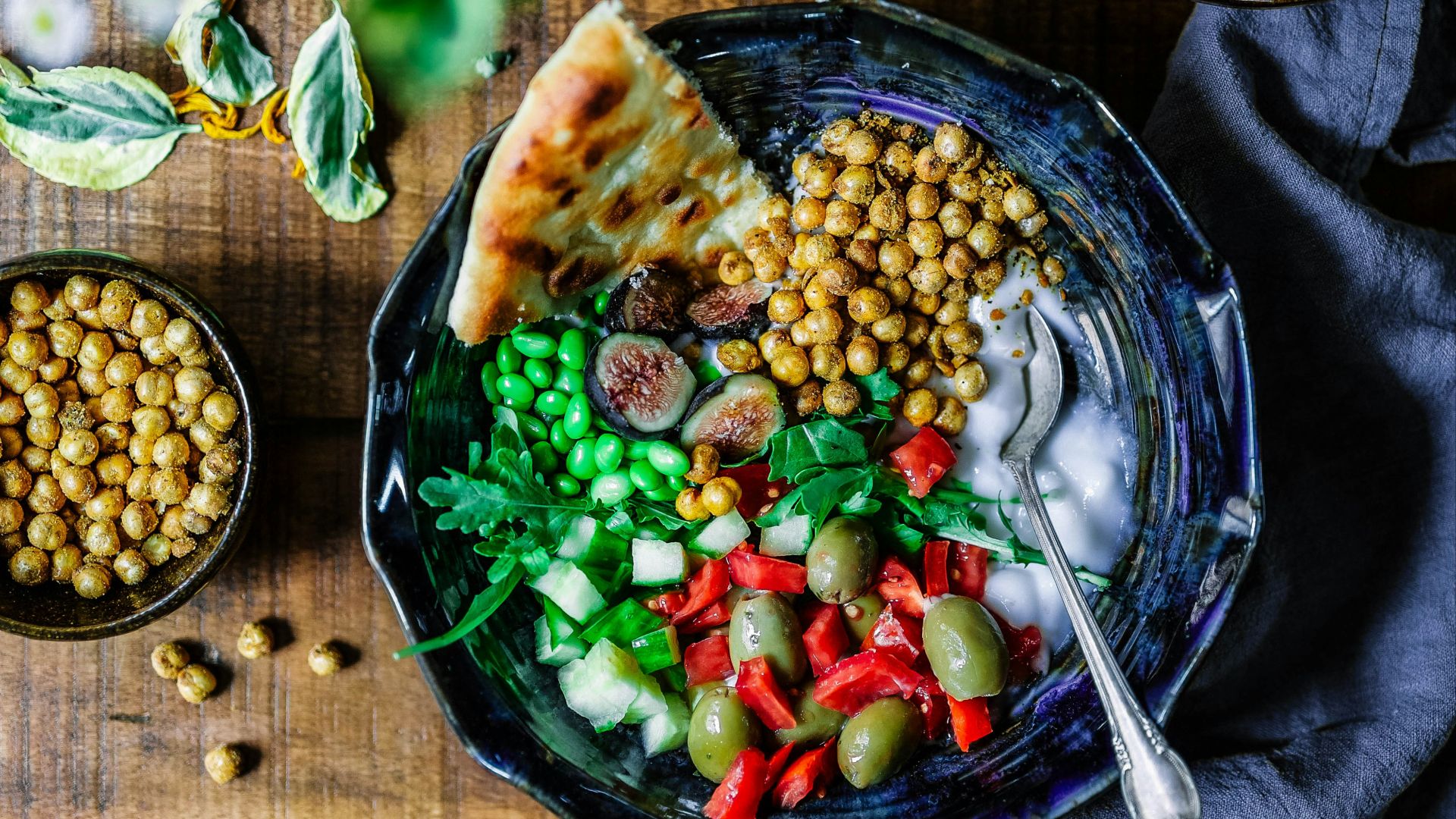 silver spoon on black ceramic bowl with vegetables