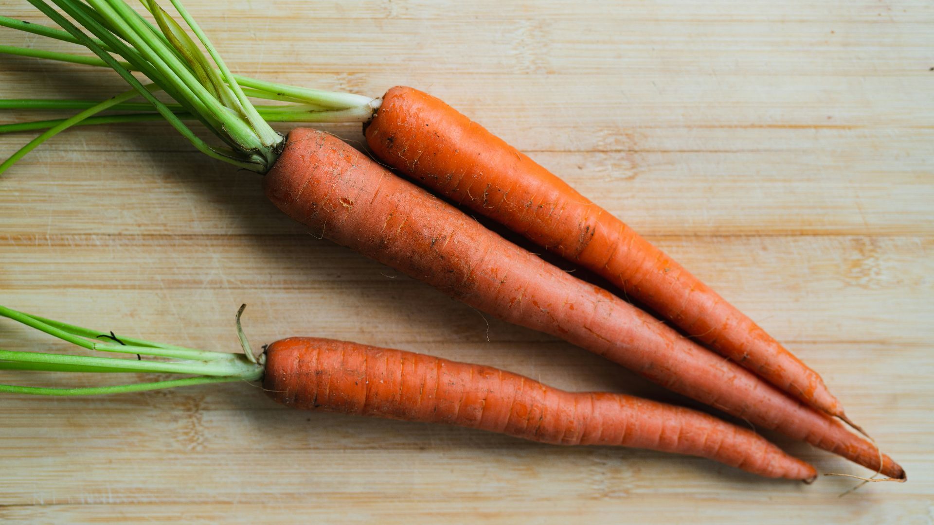 3 carrots on brown wooden table