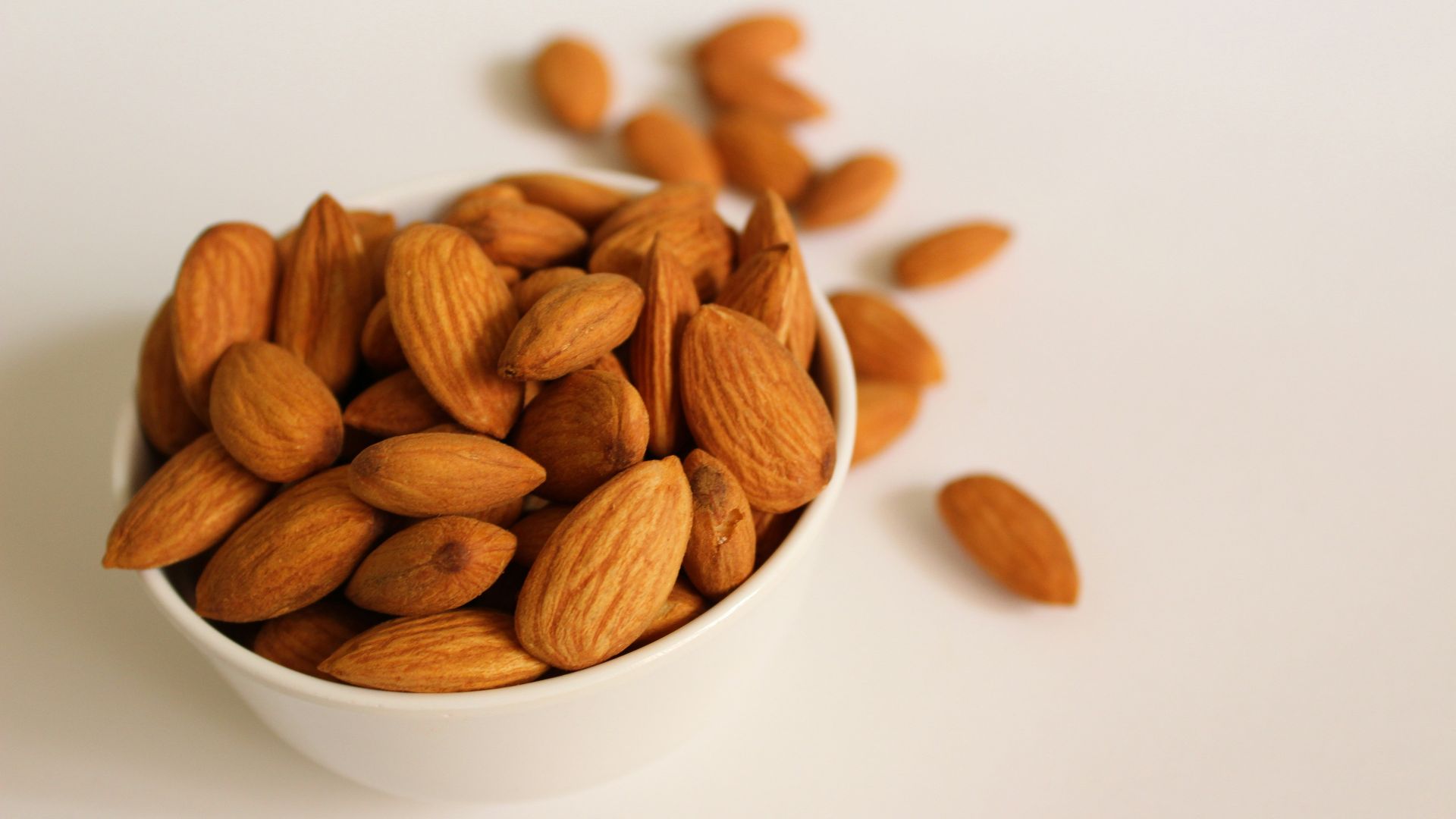 brown almond nuts on white ceramic bowl