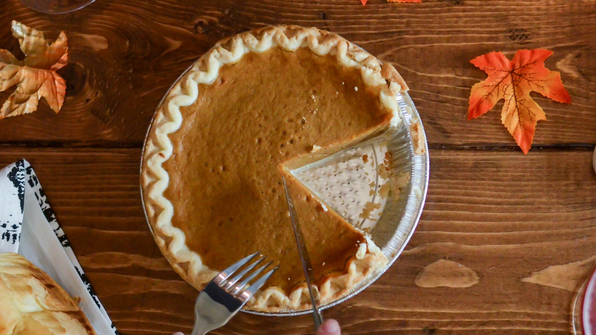 person holding table knife about to slice pancake