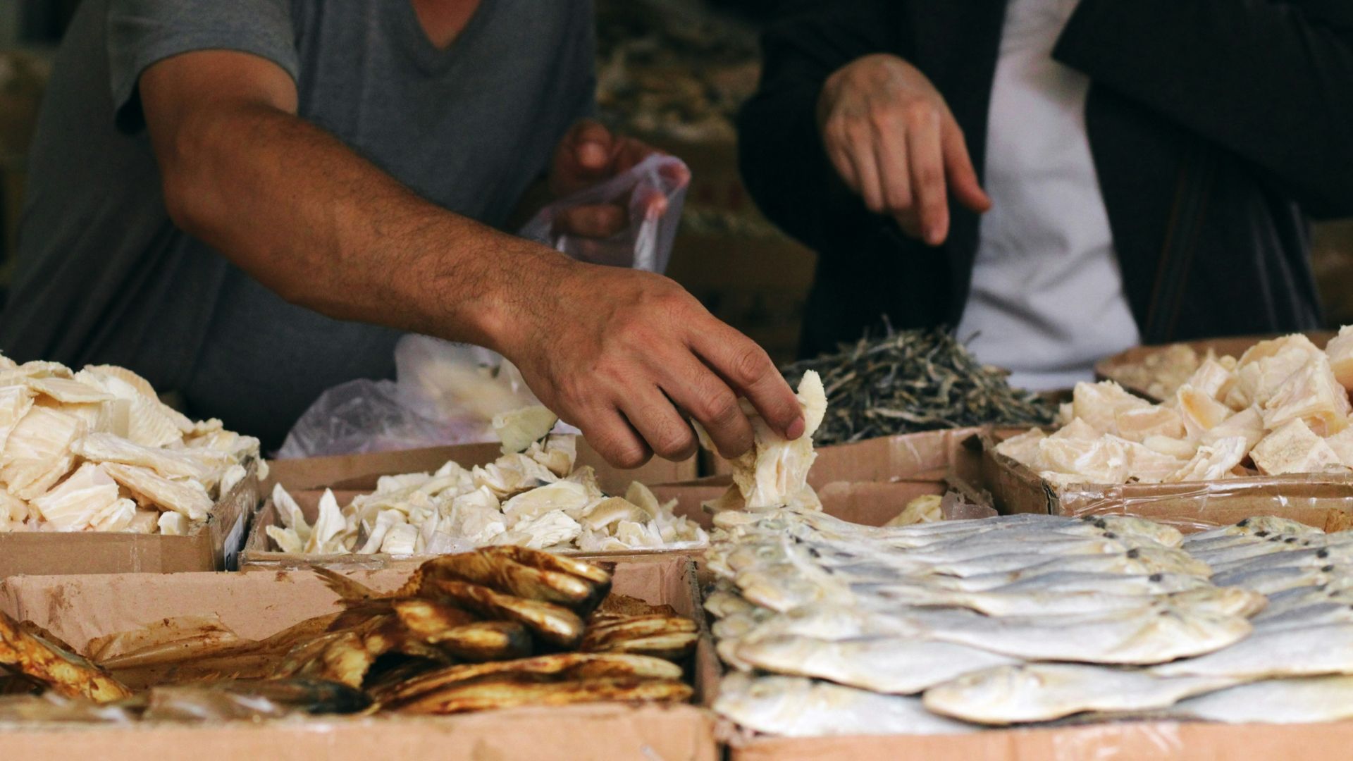 a man standing over a table filled with lots of food
