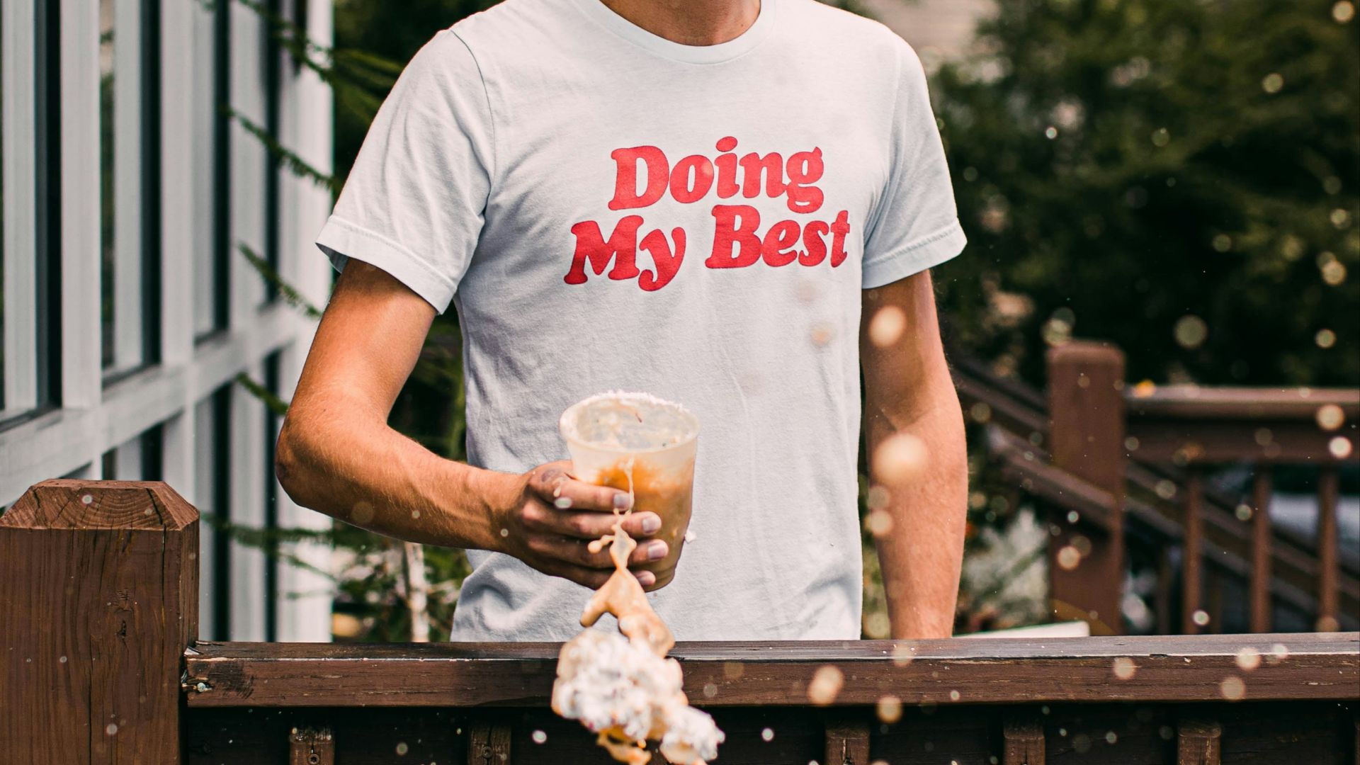 man in white crew neck t-shirt holding brown dried leaves