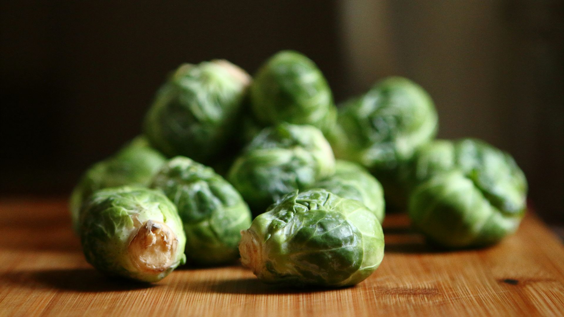 shallow depth of fields photography of green vegetable on brown wooden panel