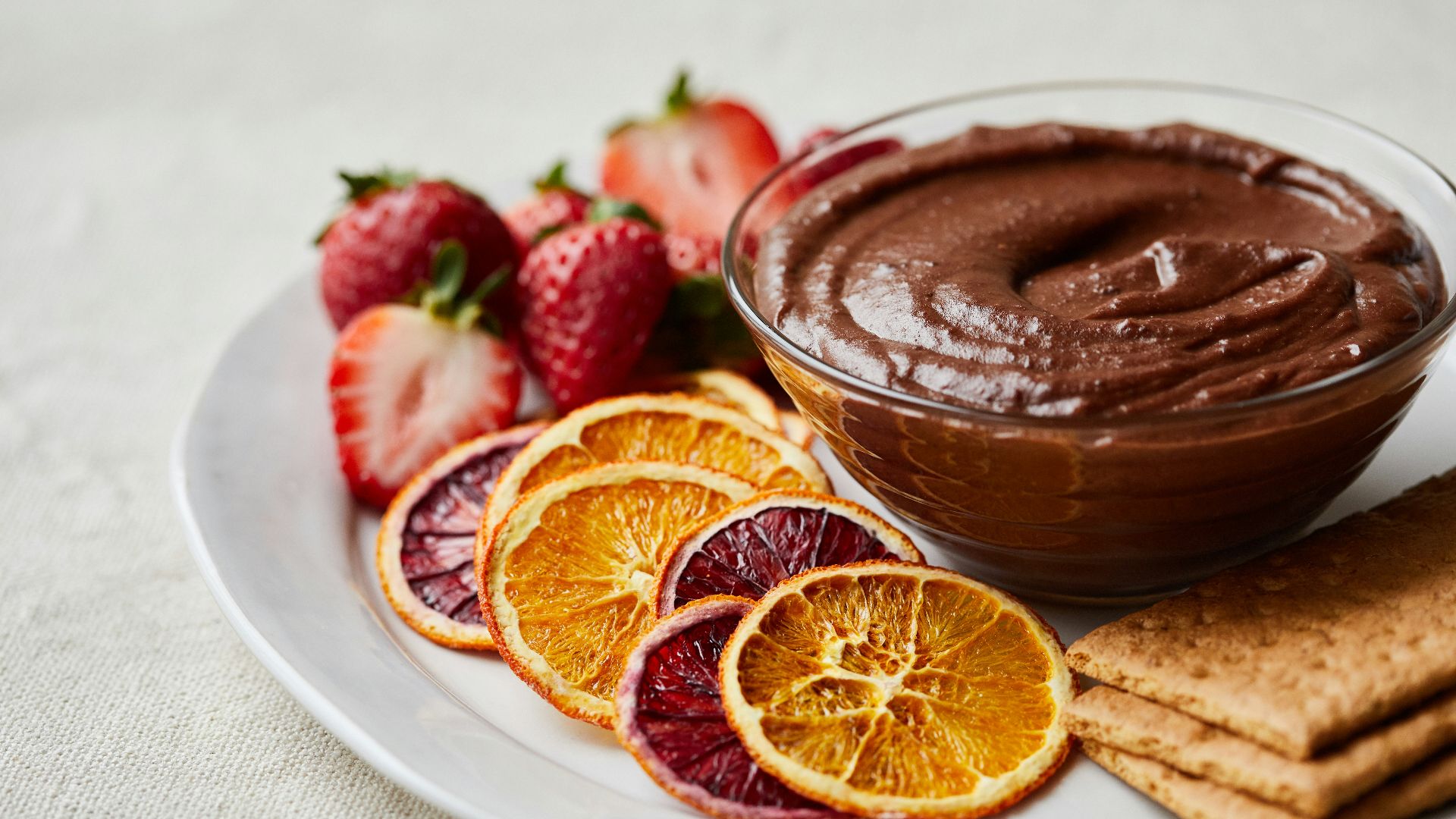 a white plate topped with fruit and a chocolate dip