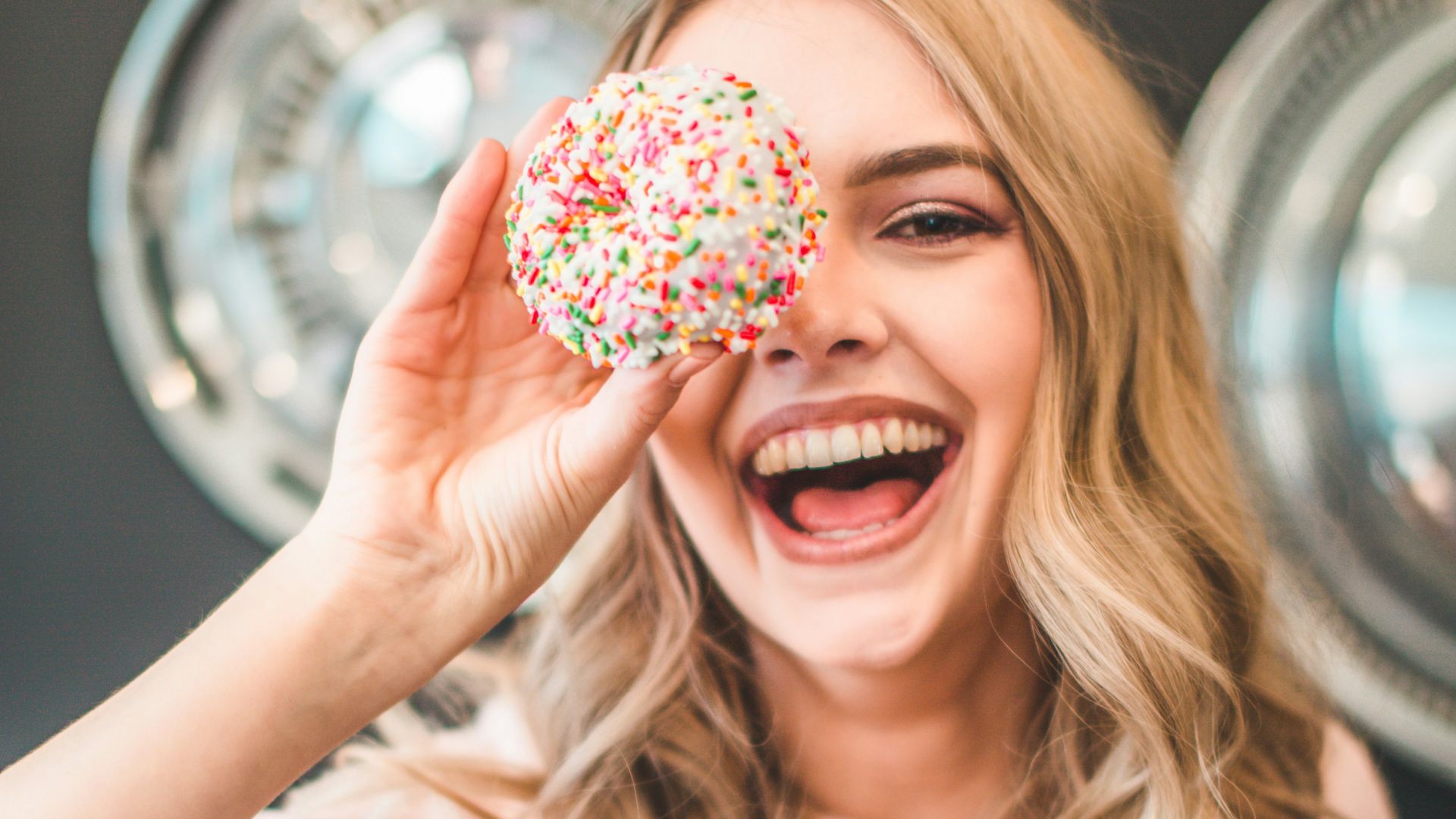 shallow focus photography of woman holding doughnut
