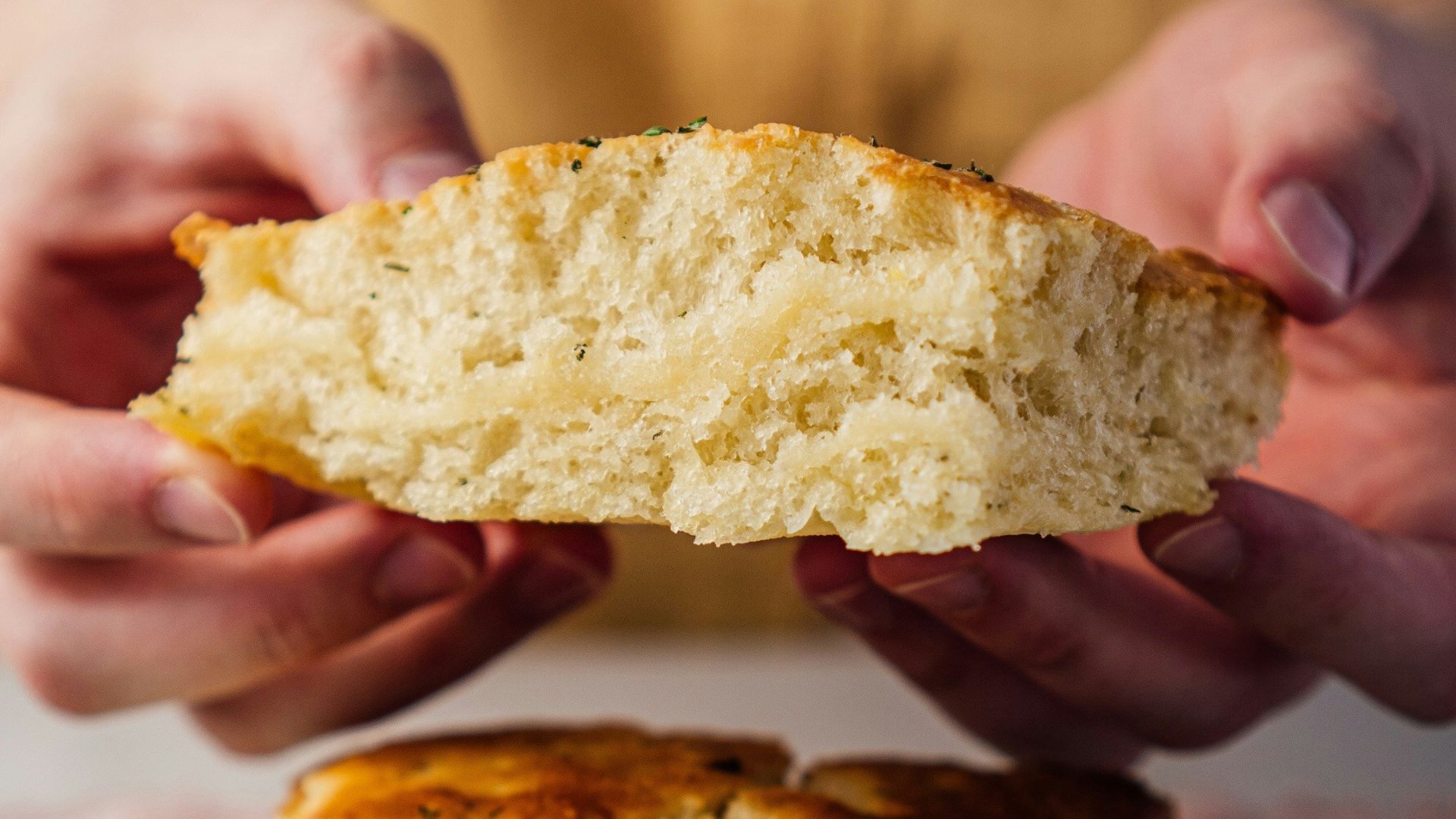 person holding bread on white ceramic plate