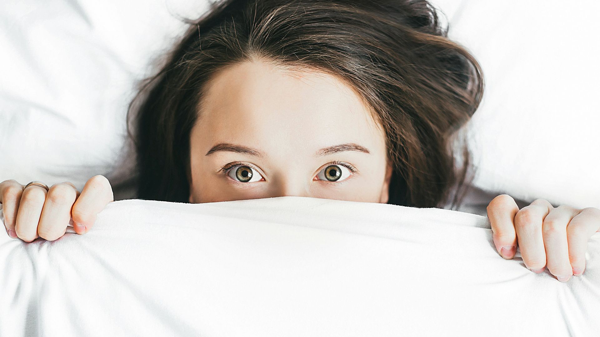woman covering her face with blanket