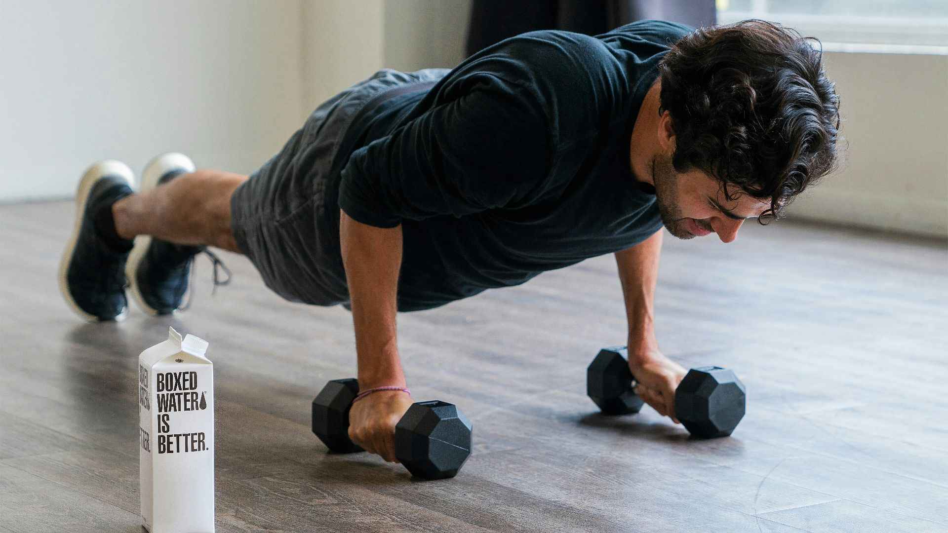 man in black t-shirt and black shorts doing push up