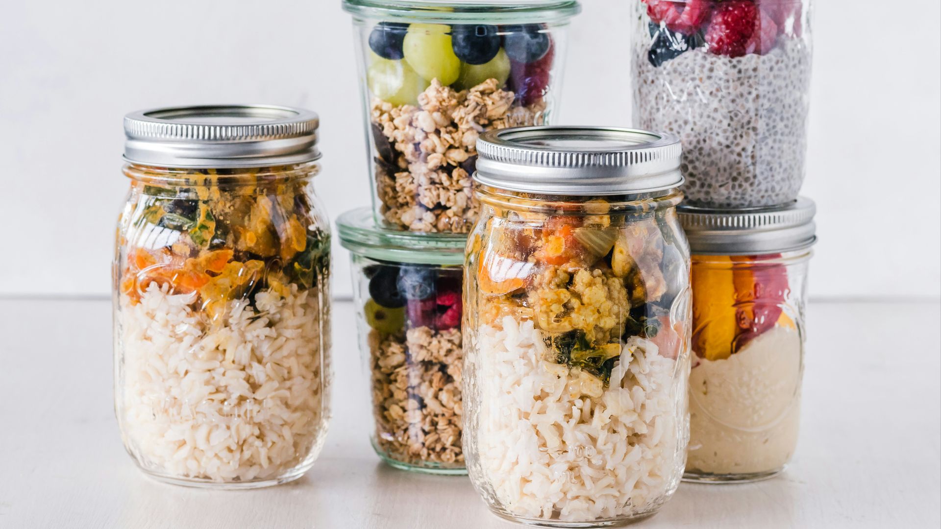 six full clear glass jars on white surface