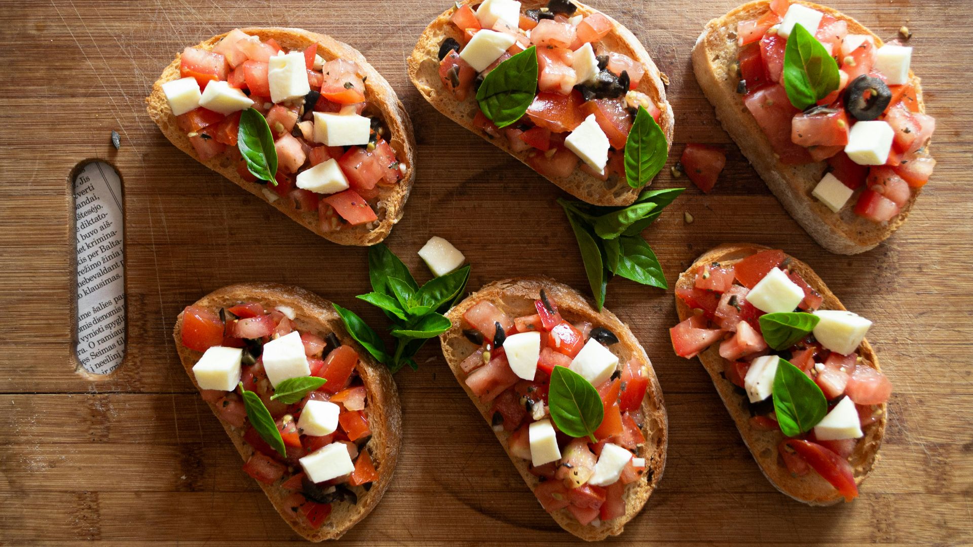 sliced tomato and green vegetable on brown wooden chopping board