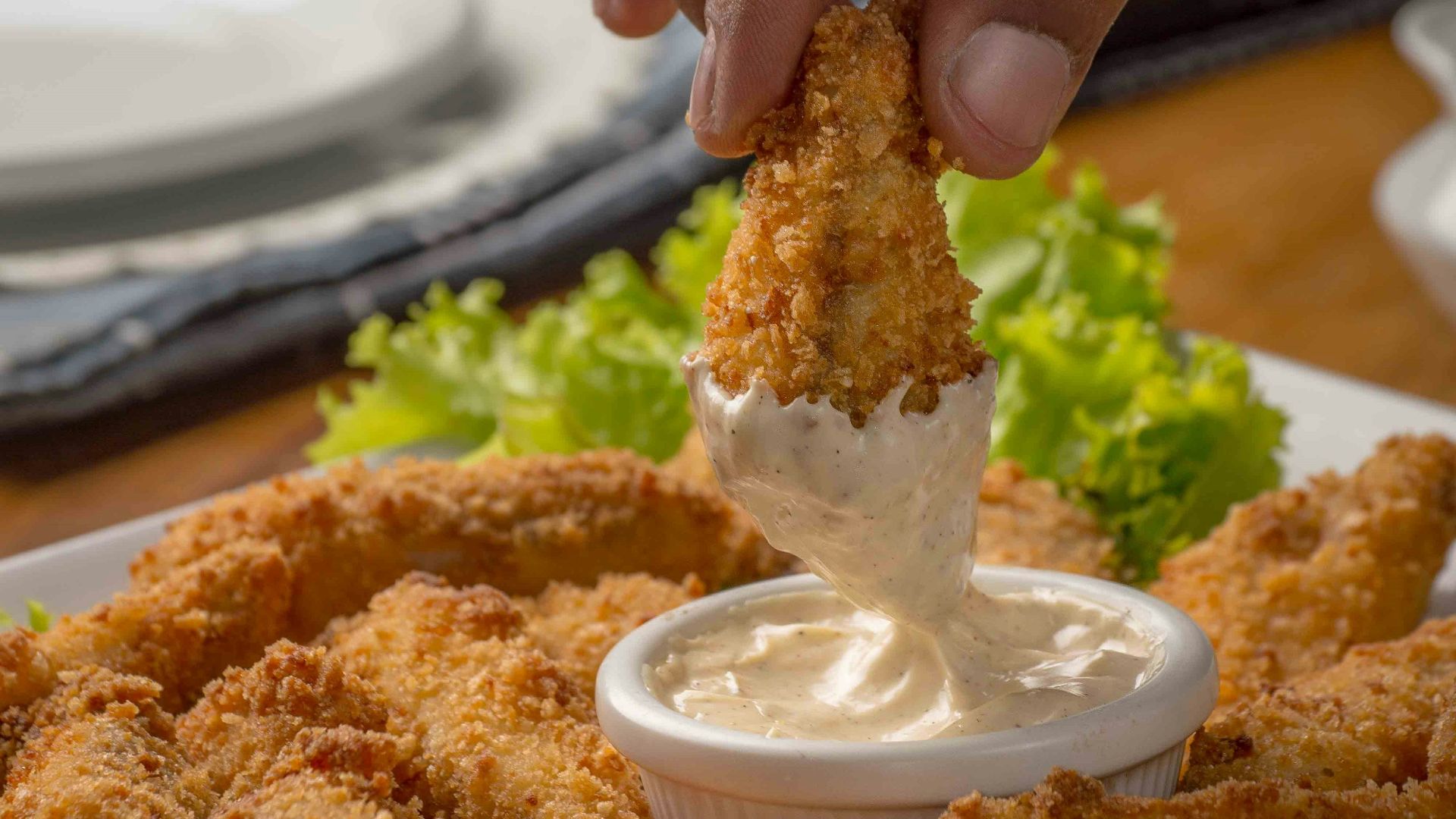 person dipping fried cuisine on dip