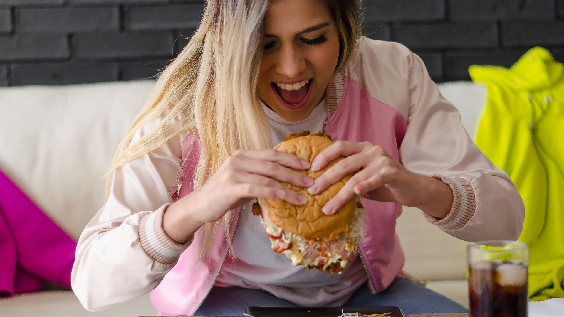 girl in pink long sleeve shirt eating bread
