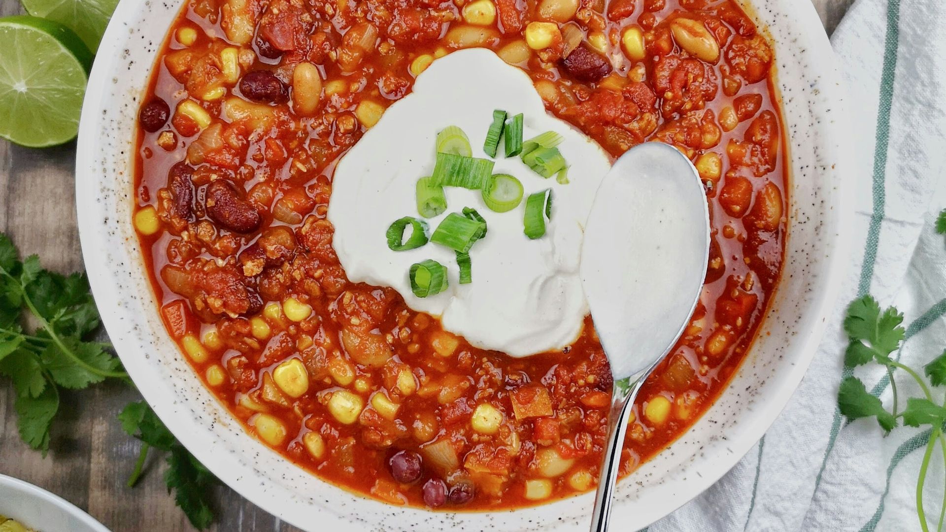 a bowl of chili with sour cream on top