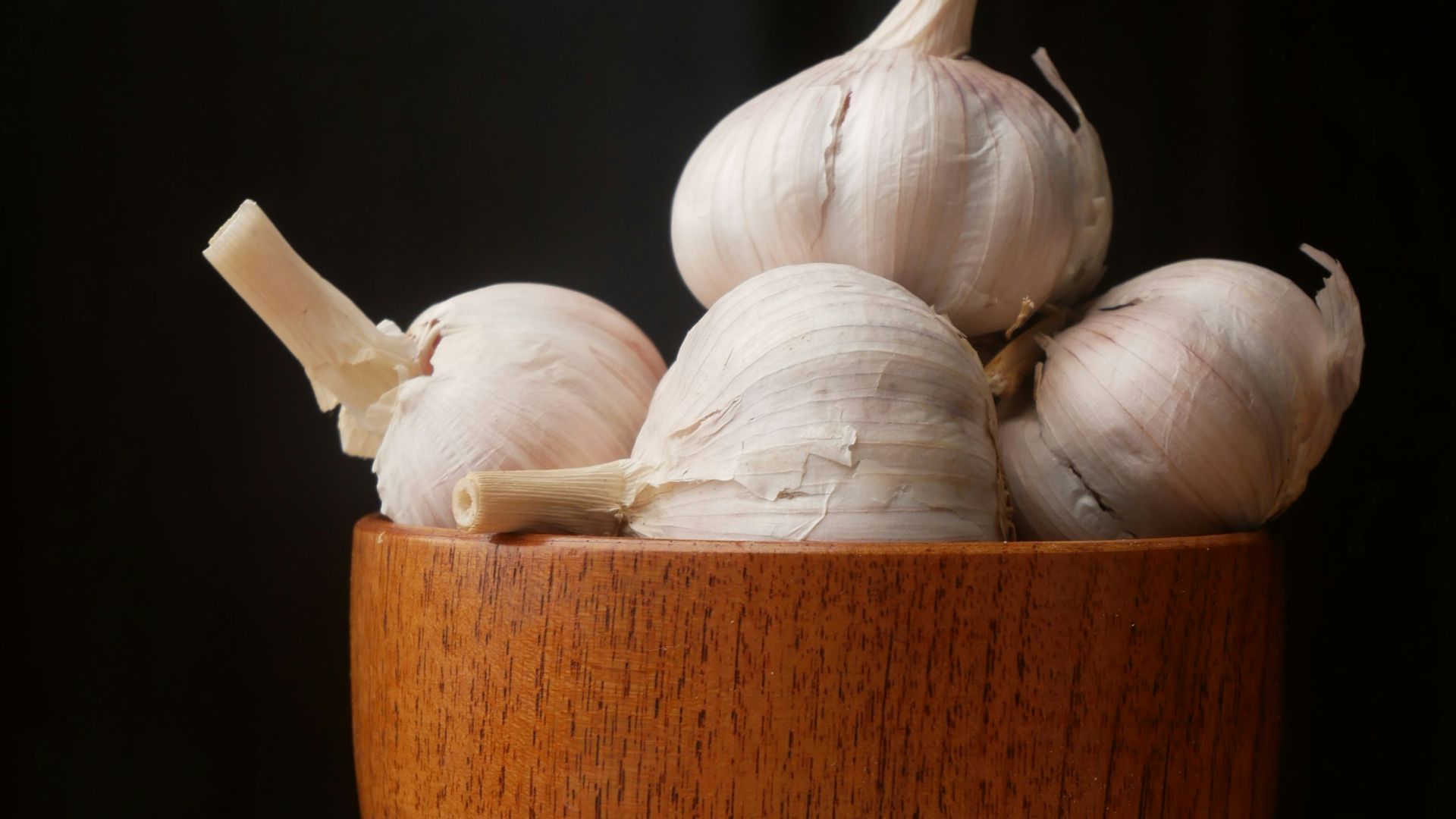 garlic on brown wooden bowl