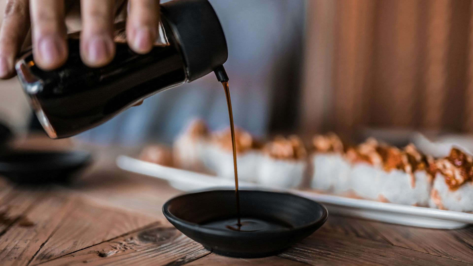 person pouring coffee on black ceramic mug