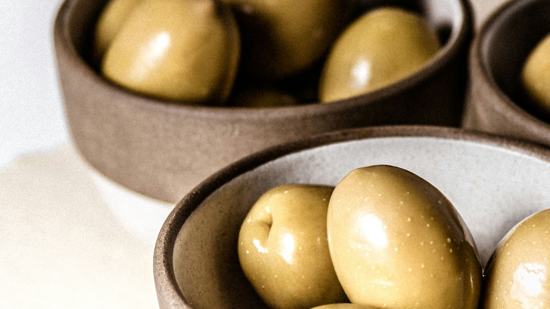 green round fruits on black ceramic bowl
