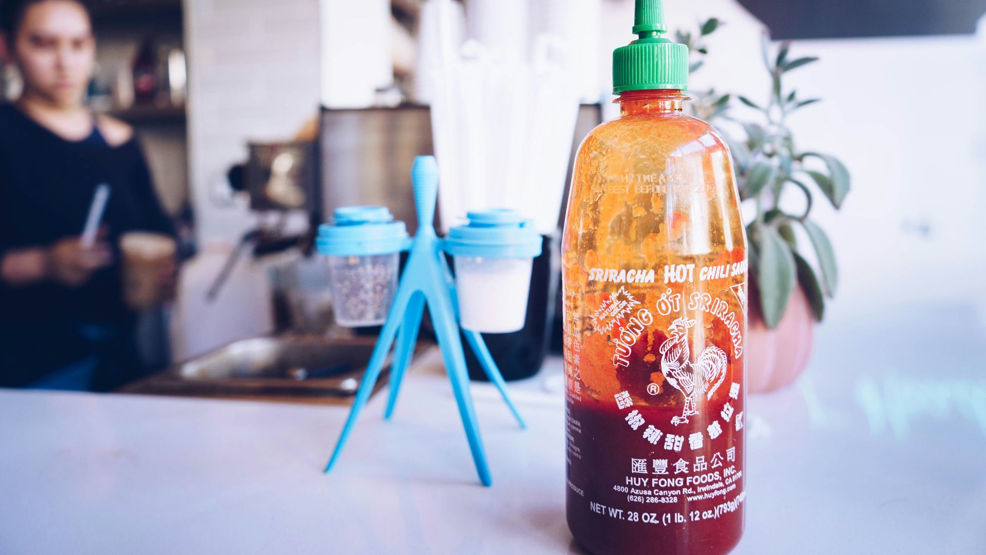 half-filled bottle beside cup rack