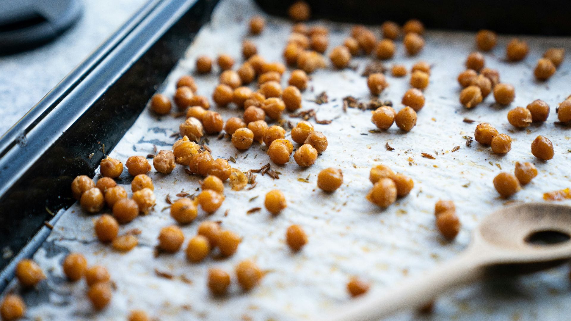 a pan filled with chickpeas and a wooden spoon