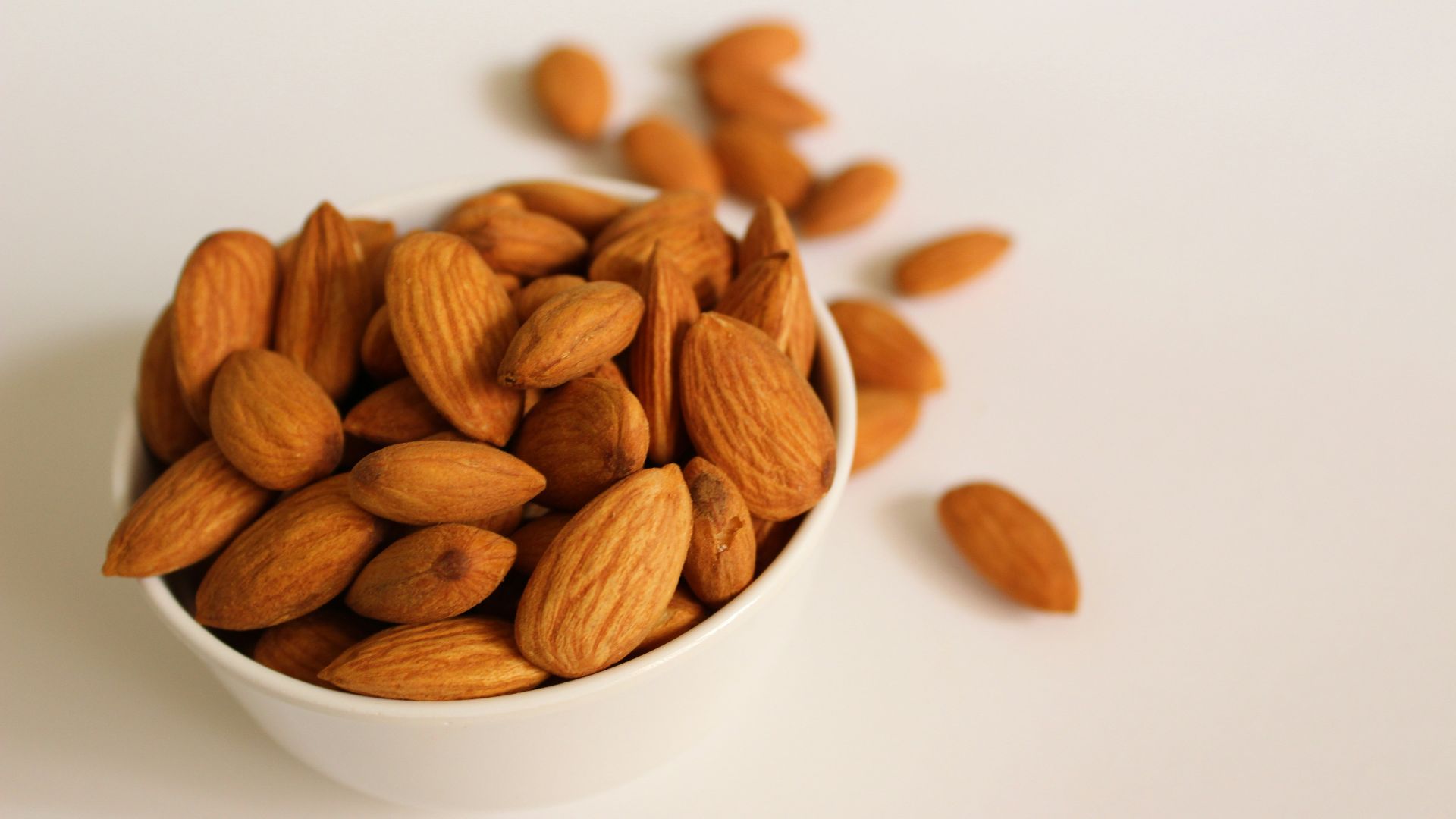 brown almond nuts on white ceramic bowl