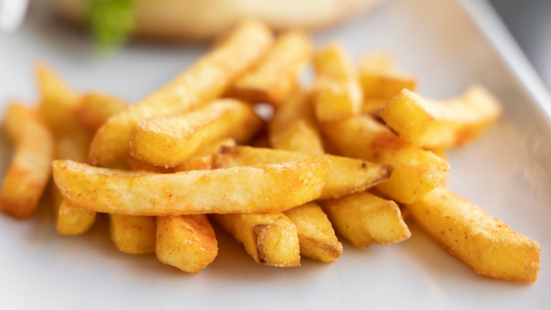a white plate topped with french fries next to a sandwich